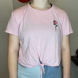 A light pink crop top with a rose in the front